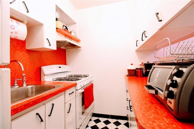 61 Oliver St Unit 5B, Brooklyn, NY 11209 - kitchen featuring gas range gas stove, a sink, white cabinetry, light countertops, and light floors