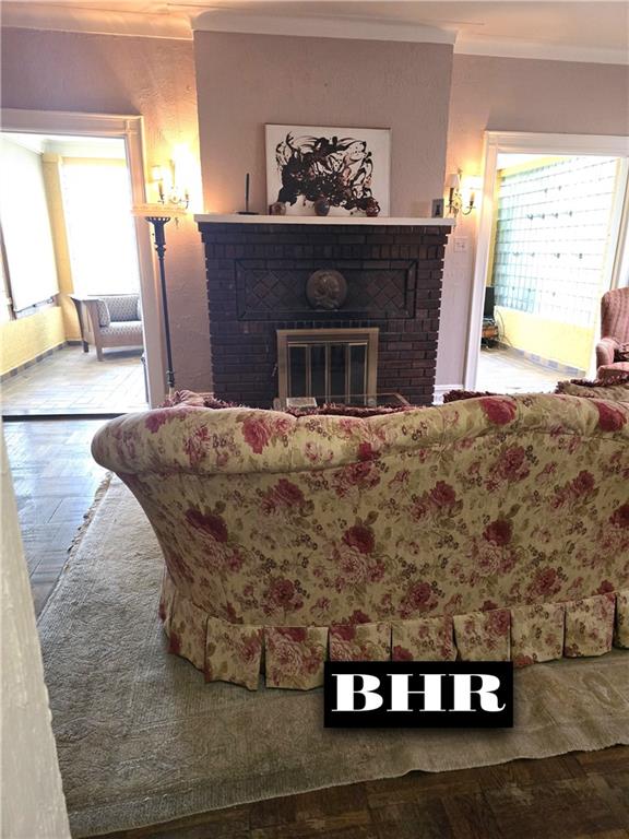 269 Coleridge St, Brooklyn, NY 11235 - living room with crown molding, plenty of natural light, and a fireplace