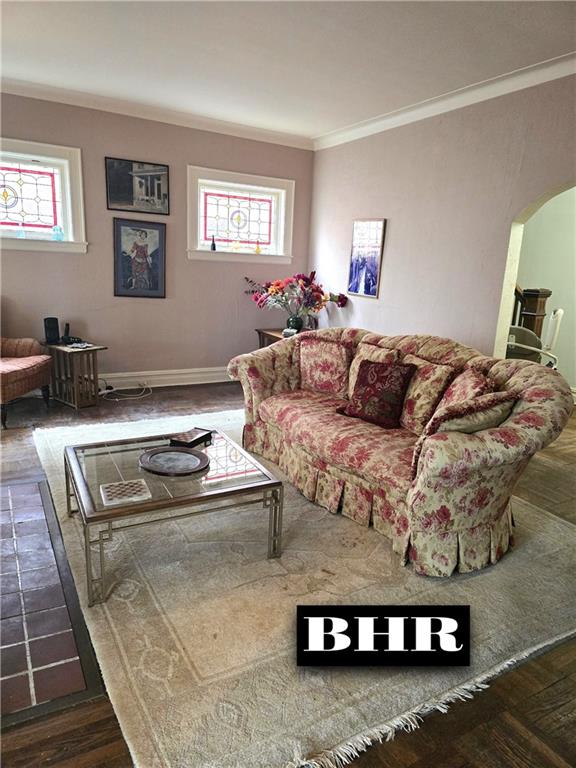 269 Coleridge St, Brooklyn, NY 11235 - living room featuring arched walkways, ornamental molding, plenty of natural light, wood finished floors, and baseboards