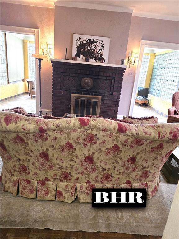 269 Coleridge St, Brooklyn, NY 11235 - living room with crown molding, a brick fireplace, wood finished floors, and healthy amount of natural light
