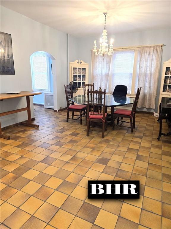269 Coleridge St, Brooklyn, NY 11235 - dining space featuring a chandelier, arched walkways, light tile patterned floors, and healthy amount of natural light