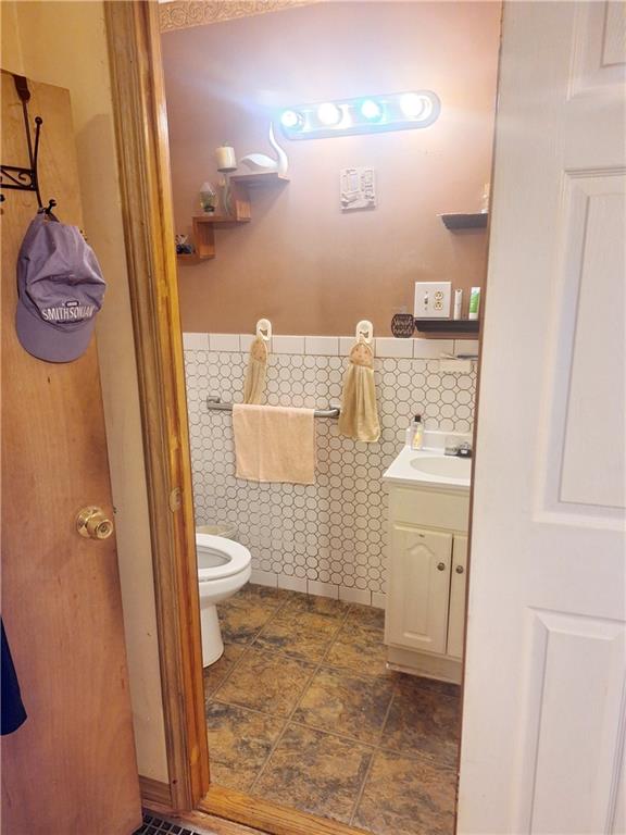 1675 72nd St, Brooklyn, NY 11204 - bathroom featuring vanity, tile walls, and a wainscoted wall