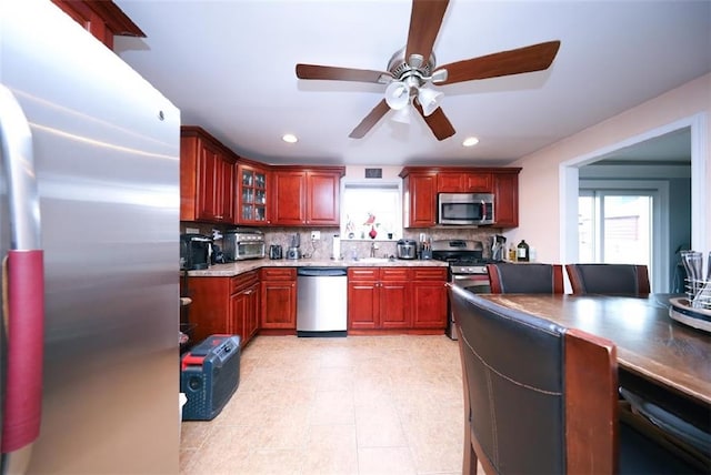 28 Trinity Pl, Staten Island, NY 10310 - kitchen with stainless steel appliances, reddish brown cabinets, backsplash, a ceiling fan, and recessed lighting