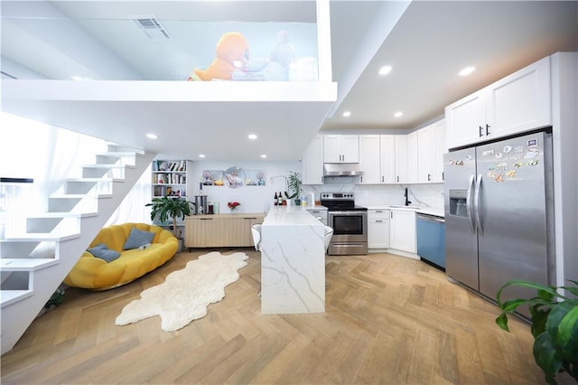4 Lake Ave, Brooklyn, NY 11235 - kitchen with stainless steel appliances, under cabinet range hood, a peninsula, white cabinets, and recessed lighting
