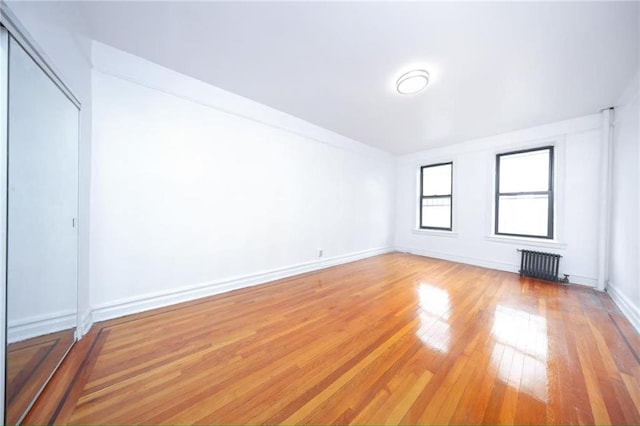 1543 W 1st St Unit D1, Brooklyn, NY 11204 - spare room with radiator, light wood-style floors, and baseboards