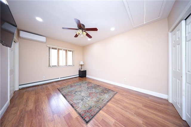177 Russek Dr Unit 1, Staten Island, NY 10312 - unfurnished bedroom featuring an AC wall unit, attic access, baseboard heating, wood finished floors, and baseboards