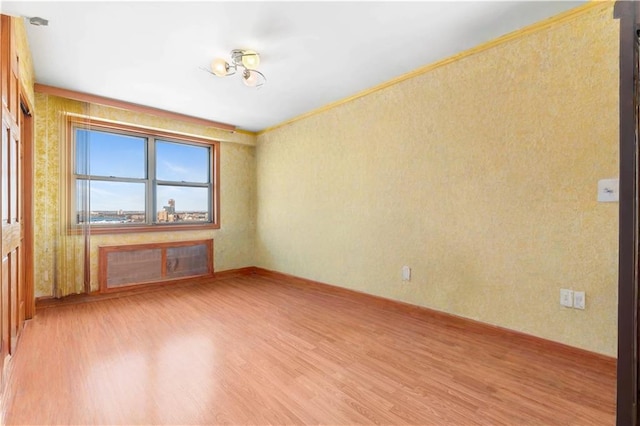 2475 W 16th St Unit 9H, Brooklyn, NY 11214 - empty room with light wood-style floors, wallpapered walls, and baseboards