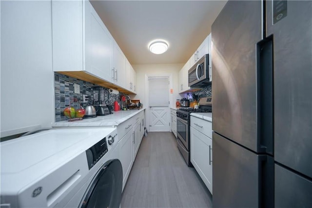 1711 Bay Ridge Parkway, Brooklyn, NY 11204 - kitchen featuring appliances with stainless steel finishes, washer / dryer, tasteful backsplash, a sink, and white cabinetry