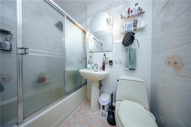 1711 Bay Ridge Parkway, Brooklyn, NY 11204 - bathroom featuring bath / shower combo with glass door, toilet, tile patterned flooring, and tile walls