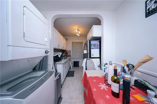 1711 Bay Ridge Parkway, Brooklyn, NY 11204 - kitchen featuring stacked washer / drying machine, white cabinetry, light tile patterned floors, and light countertops