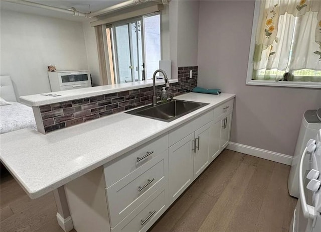 1711 Bay Ridge Parkway, Brooklyn, NY 11204 - kitchen featuring washing machine and dryer, a sink, tasteful backsplash, a peninsula, and baseboards