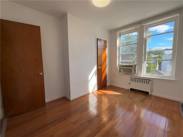 1414 76th St, Brooklyn, NY 11228 - empty room featuring radiator, wood-type flooring, baseboards, and cooling unit