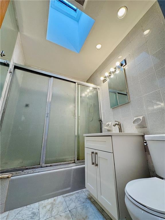 1414 76th St, Brooklyn, NY 11228 - bathroom featuring a skylight, toilet, combined bath / shower with glass door, vanity, and recessed lighting