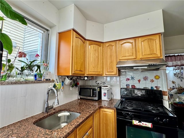 1414 76th St, Brooklyn, NY 11228 - kitchen featuring black gas range, under cabinet range hood, stainless steel microwave, a sink, and decorative backsplash