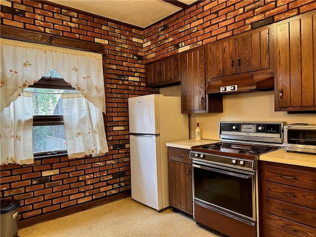 974 77th St, Brooklyn, NY 11228 - kitchen with stove, premium range hood, freestanding refrigerator, light countertops, and brick wall