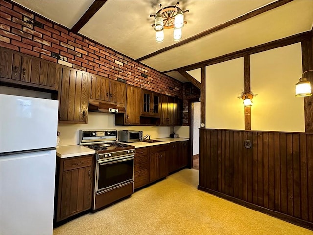 974 77th St, Brooklyn, NY 11228 - kitchen with freestanding refrigerator, stainless steel gas range oven, a sink, under cabinet range hood, and light countertops