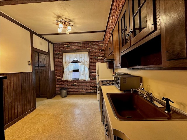 974 77th St, Brooklyn, NY 11228 - kitchen with a sink, brick wall, wainscoting, light countertops, and dark brown cabinets