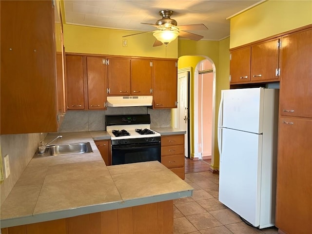 2315 E 17th St, Brooklyn, NY 11229 - kitchen featuring freestanding refrigerator, gas range oven, under cabinet range hood, a sink, and tasteful backsplash