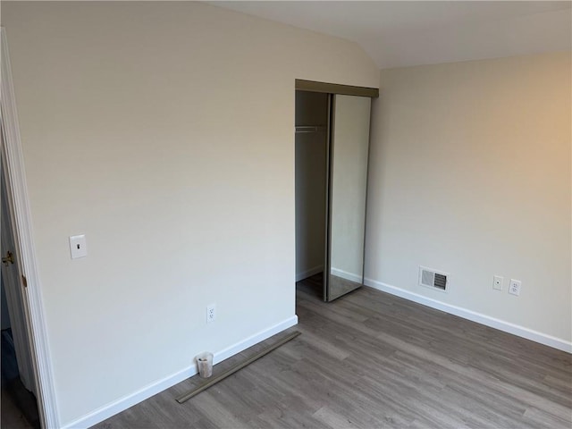 7 Georgetown Ln, Brooklyn, NY 11234 - unfurnished bedroom featuring wood finished floors, baseboards, a closet, and vaulted ceiling