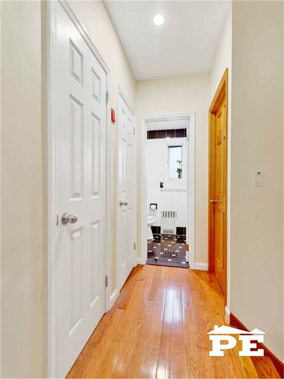 2077 Hendrickson St, Brooklyn, NY 11234 - corridor featuring radiator, light wood-style floors, baseboards, and recessed lighting