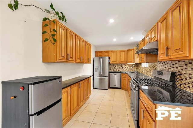 2077 Hendrickson St, Brooklyn, NY 11234 - kitchen featuring appliances with stainless steel finishes, under cabinet range hood, decorative backsplash, a sink, and light tile patterned floors