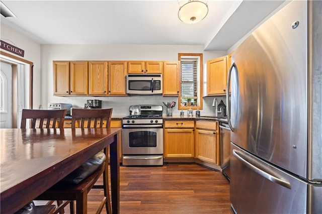 680 81st St Unit 1B, Brooklyn, NY 11228 - kitchen with stainless steel appliances, dark countertops, dark wood finished floors, decorative backsplash, and a sink