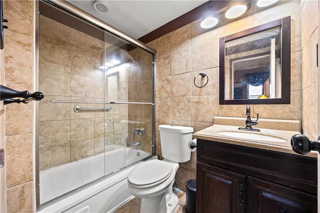 680 81st St Unit 1B, Brooklyn, NY 11228 - bathroom with tile walls, vanity, toilet, and bath / shower combo with glass door