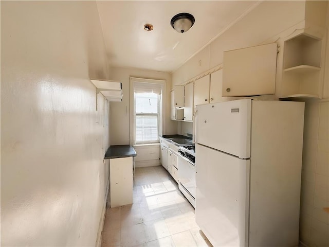 1685 E 2nd St, Brooklyn, NY 11223 - kitchen featuring white appliances, light floors, white cabinets, and dark countertops