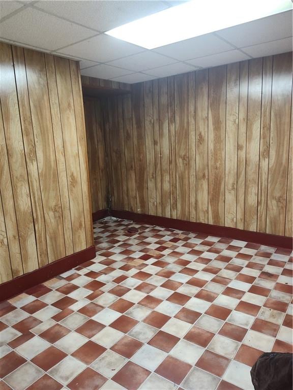324 E 26th St, Brooklyn, NY 11226 - finished below grade area with a paneled ceiling, wood walls, baseboards, and light floors