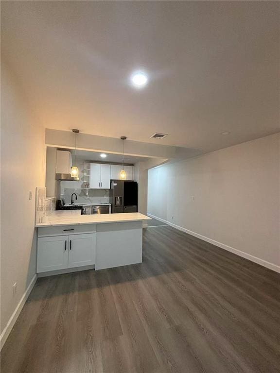 555 W 149th St Unit 4, New York, NY 10031 - kitchen featuring fridge with ice dispenser, a peninsula, dark wood-type flooring, light countertops, and pendant lighting