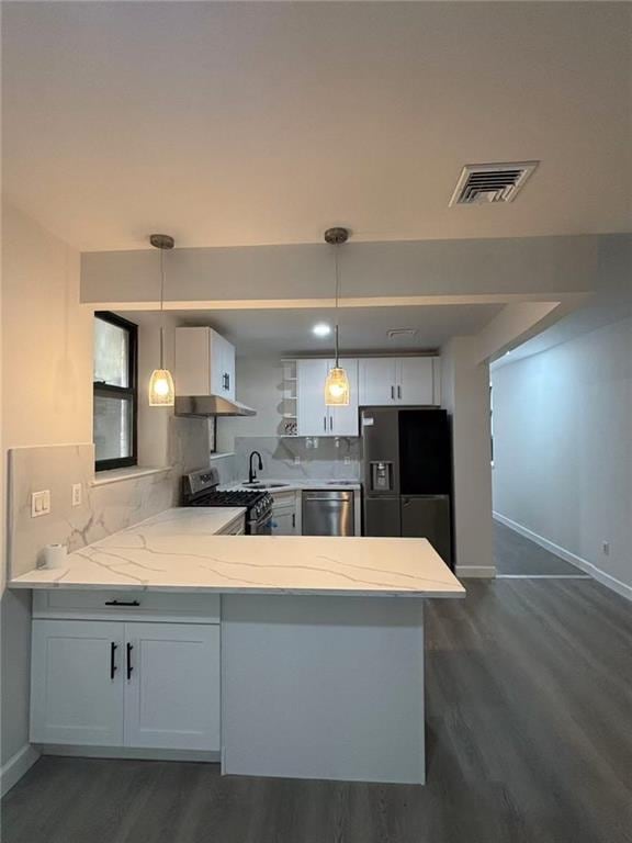 555 W 149th St Unit 4, New York, NY 10031 - kitchen featuring stainless steel appliances, baseboards, dark wood finished floors, a peninsula, and range hood