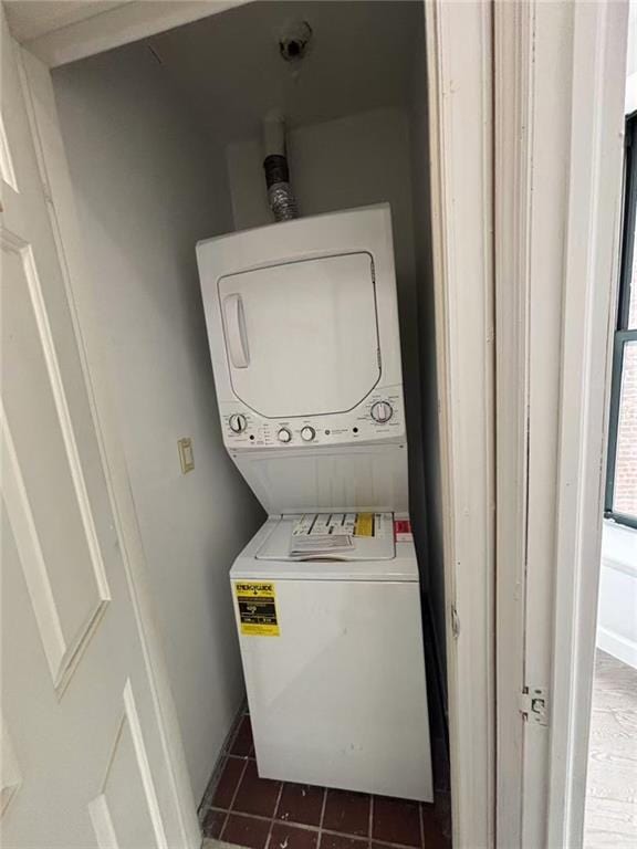 555 W 149th St Unit 4, New York, NY 10031 - laundry room with stacked washer / drying machine and dark tile patterned flooring