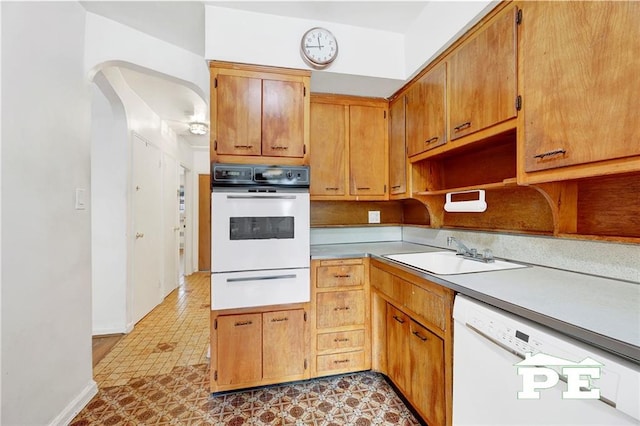 5709 Fillmore Ave, Brooklyn, NY 11234 - kitchen with white appliances, a warming drawer, a sink, arched walkways, and light countertops