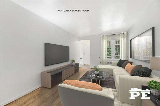 5709 Fillmore Ave, Brooklyn, NY 11234 - living room with arched walkways, wood finished floors, and baseboards