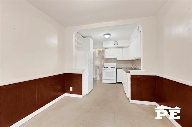 5709 Fillmore Ave, Brooklyn, NY 11234 - kitchen featuring white appliances, white cabinetry, a sink, and a wainscoted wall