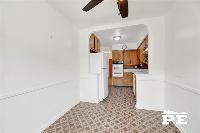 5709 Fillmore Ave, Brooklyn, NY 11234 - kitchen featuring white appliances, a warming drawer, light flooring, ceiling fan, and brown cabinets