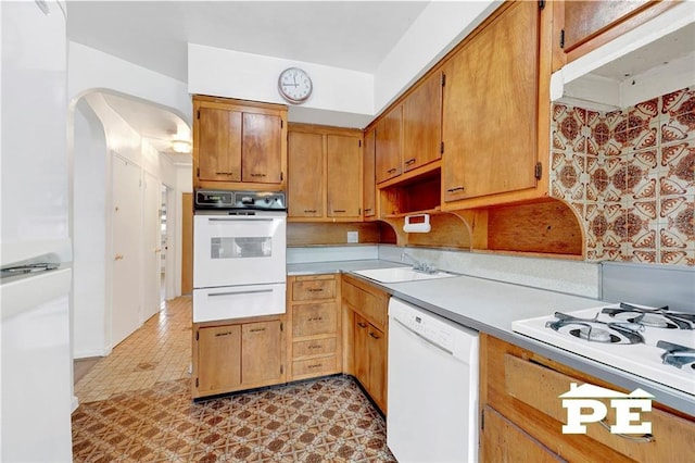 5709 Fillmore Ave, Brooklyn, NY 11234 - kitchen featuring white appliances, a warming drawer, arched walkways, under cabinet range hood, and a sink