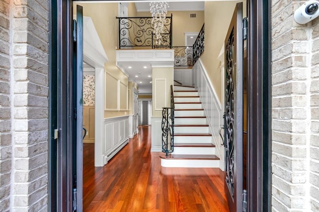 476 Hargold Ave, Staten Island, NY 10309 - foyer with a baseboard radiator, wood finished floors, stairway, wainscoting, and a decorative wall