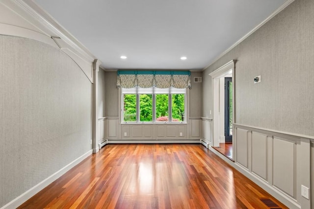 476 Hargold Ave, Staten Island, NY 10309 - spare room featuring wood finished floors, ornamental molding, a baseboard heating unit, a decorative wall, and wainscoting