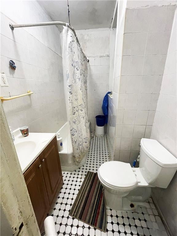 2125 E 9th St, Brooklyn, NY 11223 - full bathroom with tile walls, vanity, toilet, shower / bath combination with curtain, and tile patterned flooring
