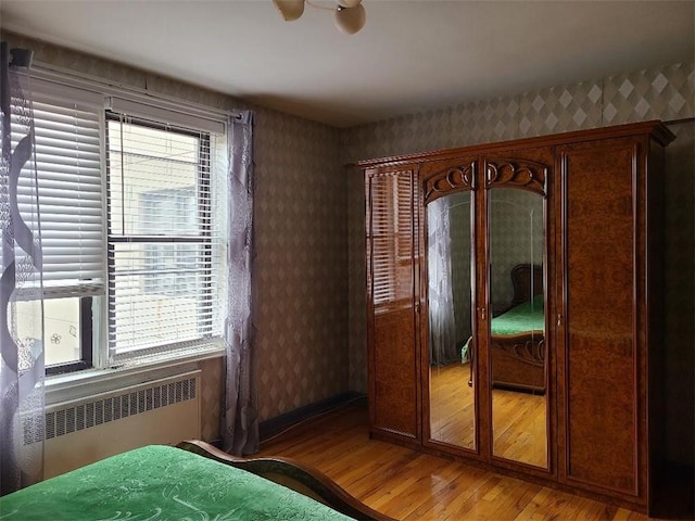 1811 Ocean Pkwy Unit 6-L, Brooklyn, NY 11223 - bedroom with radiator heating unit, light wood-type flooring, wallpapered walls, and a closet