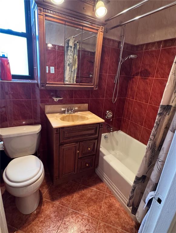 1811 Ocean Pkwy Unit 6-L, Brooklyn, NY 11223 - bathroom with tile walls, vanity, toilet, shower / bathtub combination with curtain, and tile patterned flooring