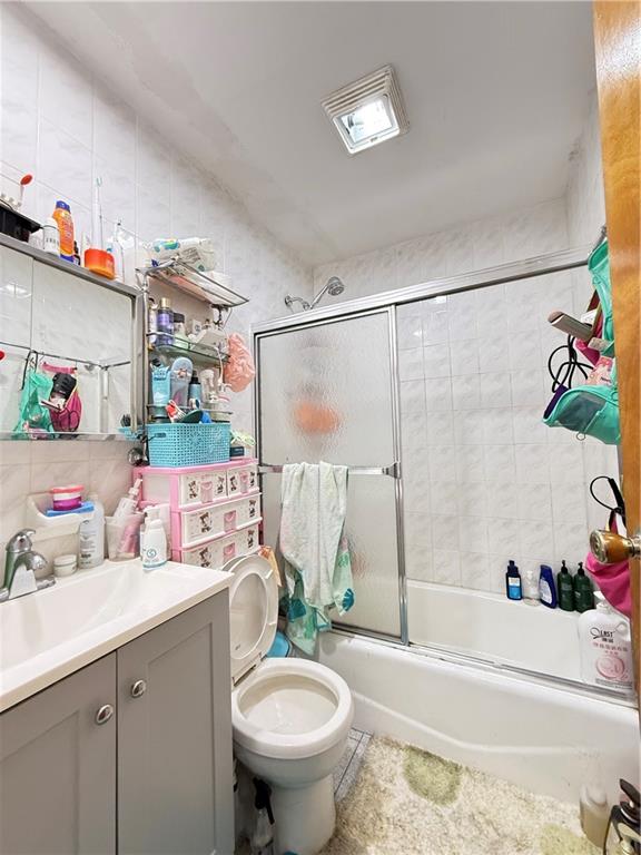 1641 82nd St, Brooklyn, NY 11214 - full bathroom featuring vanity, bath / shower combo with glass door, toilet, and decorative backsplash