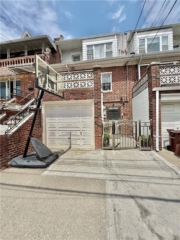 1641 82nd St, Brooklyn, NY 11214 - back of house featuring concrete driveway, brick siding, a garage, and a gate