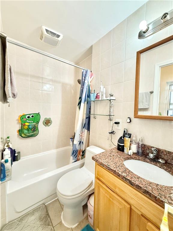 1871 W 8th St, Brooklyn, NY 11223 - full bathroom featuring tile walls, vanity, toilet, shower / tub combo, and tile patterned floors