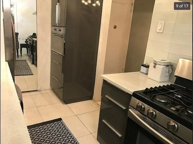 1440 Midland Ave Unit 1D, Bronxville, NY 10108 - kitchen with stainless steel range with gas stovetop, light countertops, light tile patterned floors, oven, and freestanding refrigerator