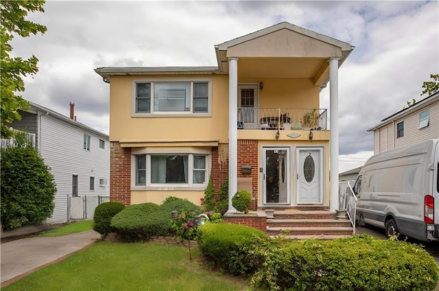 27 Bascom Pl, Staten Island, NY 10314 - view of front of house with stucco siding, a balcony, and brick siding