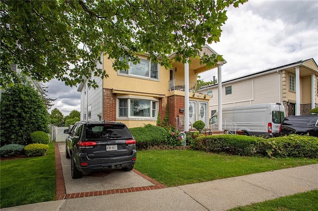 27 Bascom Pl, Staten Island, NY 10314 - view of front of property with brick siding, a balcony, a front lawn, a gate, and stucco siding