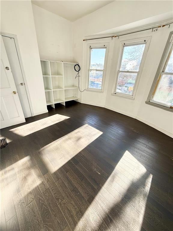 133 Quentin Rd, Brooklyn, NY 11223 - empty room with dark wood-style flooring and baseboards