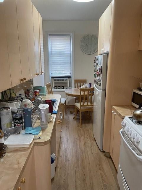 601 Brightwater Ct Unit 3I, Brooklyn, NY 11235 - kitchen with white appliances, light wood-style flooring, light countertops, cooling unit, and white cabinets